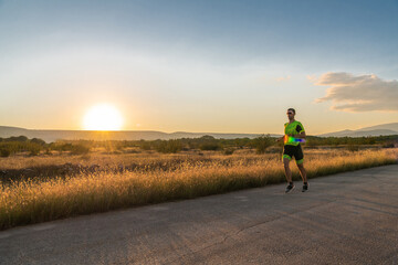 Obraz premium Triathlete in professional gear running early in the morning, preparing for a marathon, dedication to sport and readiness to take on the challenges of a marathon. 