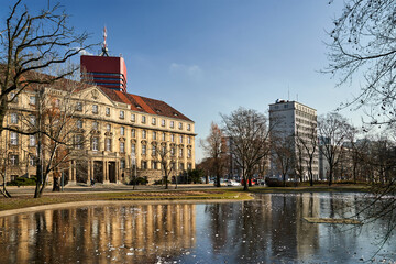 Frozen pond, street and historic building in the city of Poznan