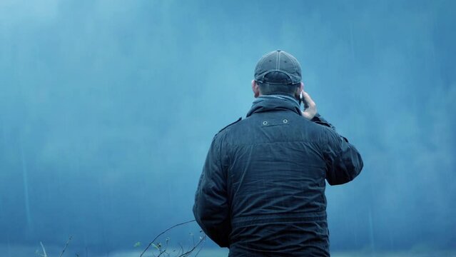 Man Talks On Phone Outside In The Rain