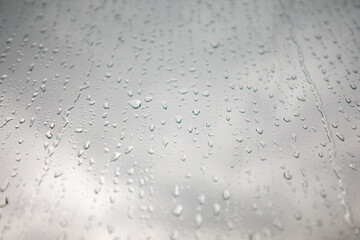 The glass of a window with natural raindrops (water drops)