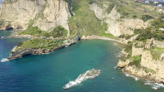 Aerial view on the Trentaremi bay of Posillipo, a district of Naples, Italy. There is a small empty beach in a cove. The coast overlooks the Mediterranean Sea.