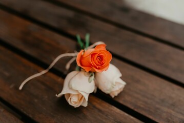 a single rose sits on a wooden surface next to a bouquet