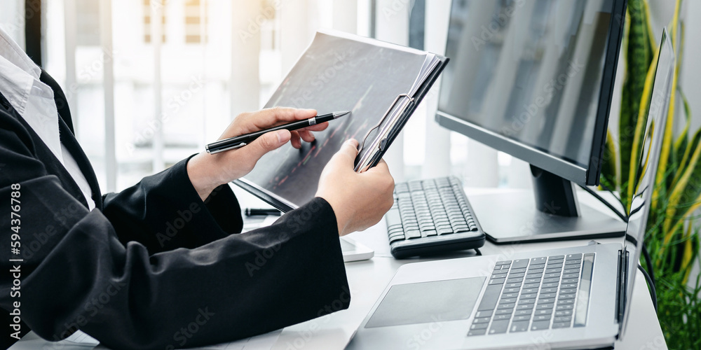 Poster businesswoman is pointing stock data chart to taking note on doc