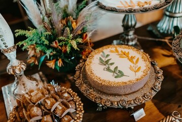 an assortment of cakes sits on a table in front of a vase and plates