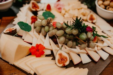 a large platter of food is displayed with grapes, figs, and other