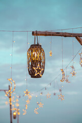 Lighting decor elements at a party outdoors. Cozy lights lanterns and light garland background. selective focus.