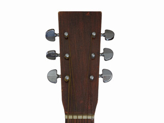 The wood headstock and metal tuning pegs of an old, homemade acoustic guitar are shown up close, set against a white background.