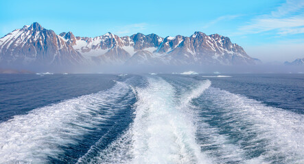 Fast moving motorboat trying to get out of the ice with rainbow in dense fog - Stranded icebergs in the fog at the mouth of the Icefjord near kulusuk, Greenland