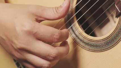 Close up right hand and moving fingers of musician playing beautiful classical guitar with string vibration shows concept of practicing for musical performance with enjoy playing instrument. 