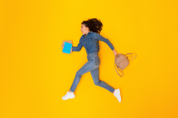Fototapeta na wymiar Shocked Woman Student Running Holding Copybooks And Backpack, Yellow Background