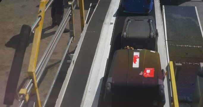 A passenger's view of luggage being loaded onto an airplane.  	