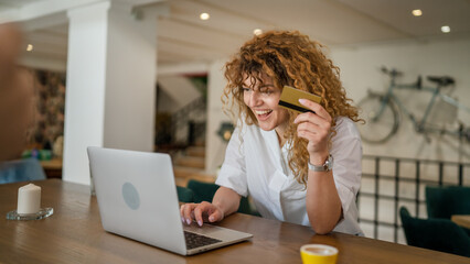 Obraz premium Woman happy caucasian female shopping online use credit card at cafe