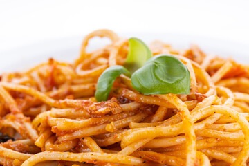 pasta on a white plate with basil leaves on a white background. pasta on a plate