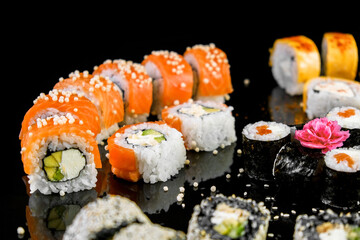 Sushi set on a black background. Fresh variety of rolls in a Japanese restaurant. Eastern cuisine.