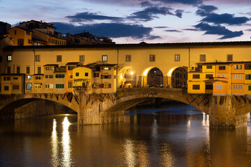 Fototapeta premium Beautiful architecture of Ponte Vecchio above Arno river, Firenze, Tuscany, Italy, Europe. Sunset evening clouds 