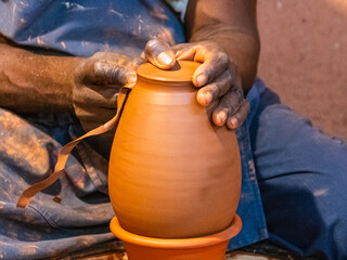 	
Gros plan sur les mains d'un homme qui fabrique une poterie en argile.	