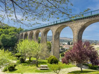 Fototapeta na wymiar Old railway bridge and garden in Vouzela, Viseu, Portugal, on a sunny afternoon.