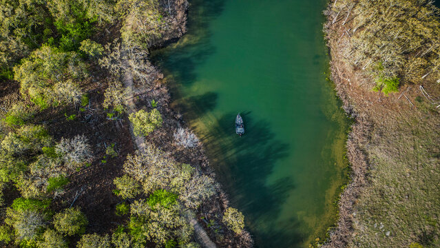Bass boat fishing in back of creek in the spring