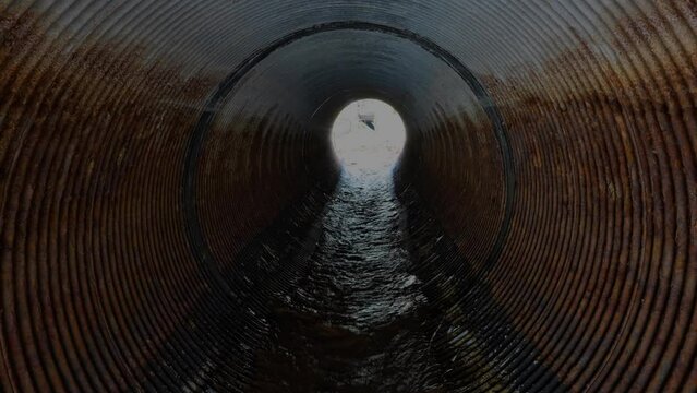 Flowing Wastewater Inside a Large Rusty Drainage Tube