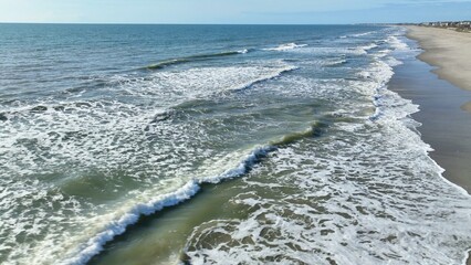 Breaking ocean waves at beach in Pawleys Island, SC coastal shoreline 