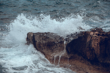 Water splashes. Waves in the sea hit the rocks on the shore
