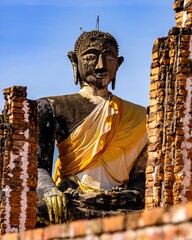 Vertical shot of an ancient and worn statue of Buddha in Wat Phiawat, Xiangkhouang, Laos