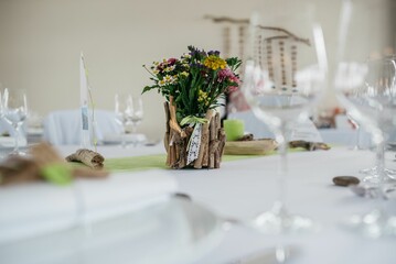 Wooden vase with colorful flowers on the table arranged for a ceremony