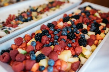 a table with two plates of fruit salad on it, each one has fruit