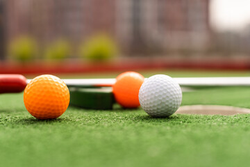 Close-up of miniature golf hole with bat and ball