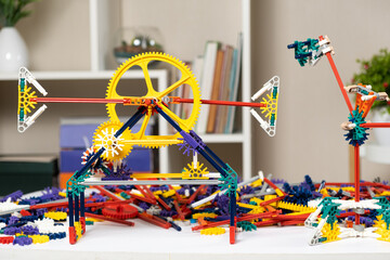 Children's constructor of gears cogwheel and sticks in the children's room. Toys for the development of logic and thinking