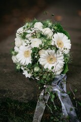 Beautiful bouquet of white roses, lilies, and snapdragons arranged in an elegant, round shape