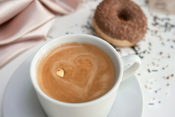 Kofe with kofe-art heart and punch, lying on a table, draped fabric