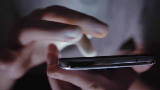 Man Using Phone in Dark, Scrolling Screen, Close-Up, Out of Focus