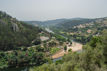 Treetops with leaves on the bank of the Mondego with aerial and panoramic view of the river beach of Reconquinho, Penacova PORTUGAL