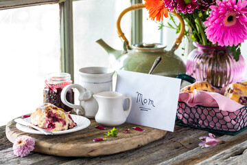 A Mother's Day arrangement with tea and scones in front of a bright window.