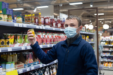 A man in a supermarket chooses food and drinks. Retail trade. Quarantine
