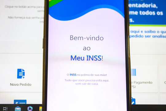 O aplicativo do INSS - Instituto Nacional do Seguro Social na tela de um telefone celular que est&aacute; sobre um laptop. Aposentadoria, Benef&iacute;cios, Brasil. 19/04/2023 - Brazil.