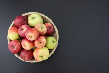Green red apples in wooden bowl on black background healthy food homegrown apples vegan vegetarian dishes organic delicious snacks