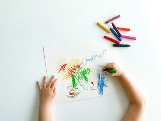 small child draws with pastel crayons on white table. fathers day - Powered by Adobe