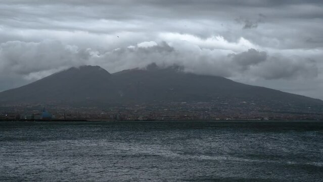 Timelapse of Vesuvius volcano from Naples Italy on a rainy day with clouds rolling over it