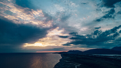 Obraz premium Aerial view of a sunset over the sandy beach ad sea coast