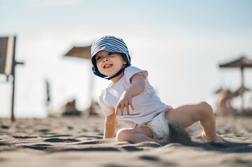 Adorable toddler child boy playing in the sand on a on beach