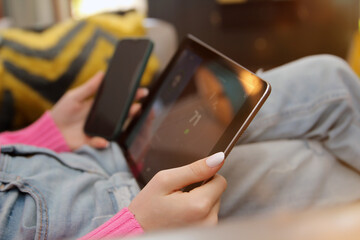 Woman  is adjusting a  temperature using a tablet with smart home app in a  modern living room.