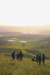 a group of people standing on top of a lush green hillside