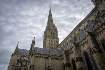 Salisbury Cathedral exterior with tallest church spire in United Kingdom.  Early English Gothic structure with clerestory windows and North transept.