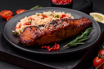 Delicious red salmon fish grilled with sauce and sesame seeds with rice and vegetables