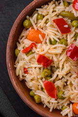 Delicious boiled rice with vegetables peppers, carrots, peas and asparagus beans