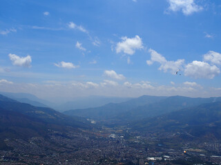 Obraz premium Medellin, Colombia - 20.05.2015: Paraglider flying above Medellin