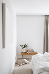 Bedroom in minimal style with bed, wooden table and cushions