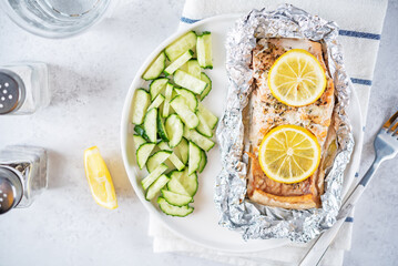 Salmon with herbs and lemon slices baked in a foil
